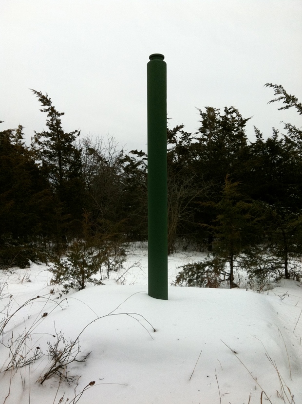 Surrounded by vegetation that would have never been there during the jet engine tests of the 1950s, the tehter post has a visble anchor pad under the snow.
